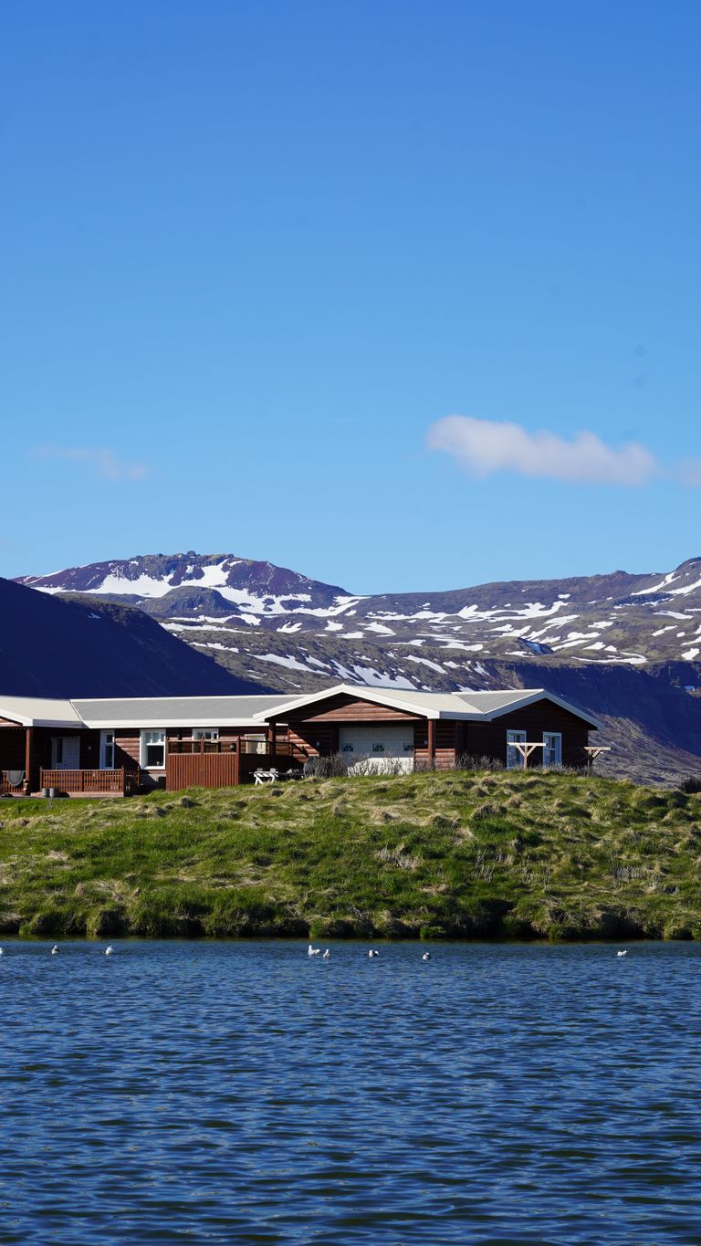 A serene remote cabin by a crystal-clear lake with stunning mountain views.
