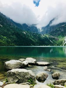 Scenic view of Morskie Oko Lake and Tatra Mountains in Poland with clouds above.